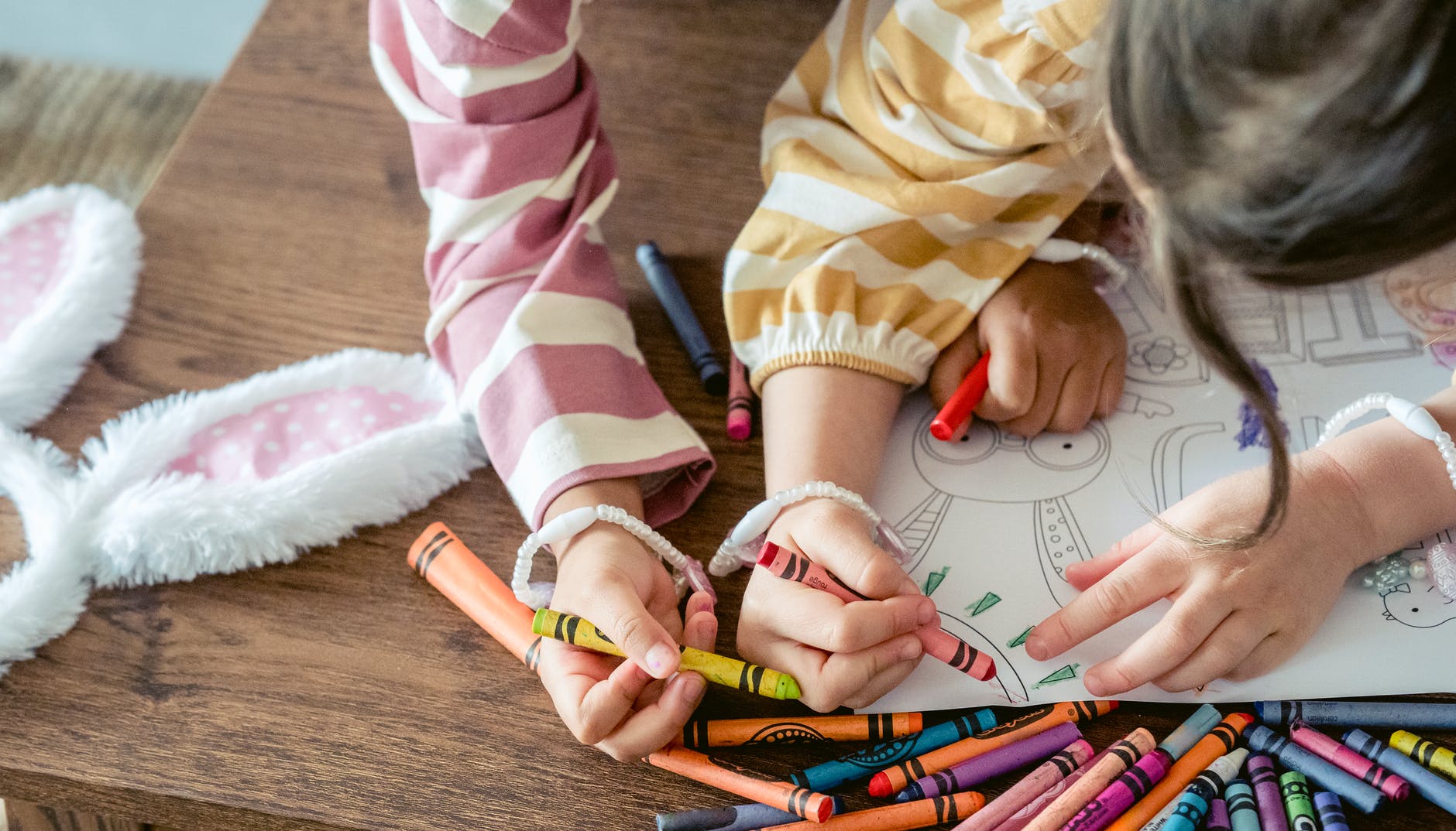 girls coloring sun on paper for easter celebration